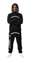 Black matching sweatsuit with bold white graphics, paired with white sneakers for streetwear style